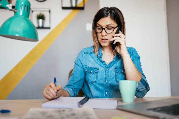 istock Woman using smart phone from home office, dealing with finances and e-banking 1217210367