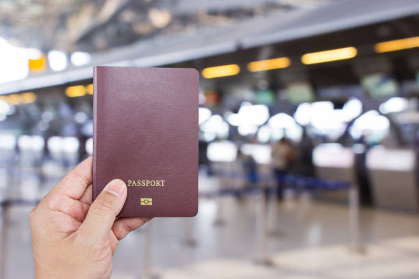 istock Man's hand holding international passport while wait at front the counter for check-in inside Suvarnabhumi Airport Samutprakan. Thailand. 1217210810