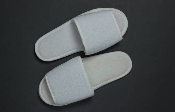 istock White sleeping slippers on a black background. Top view 1217212573