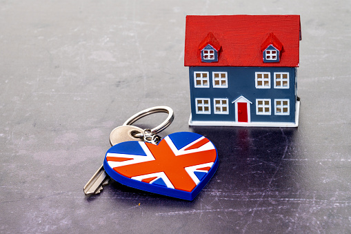 House with a door key and keyring in the shape of a heart and printed with a UK flag