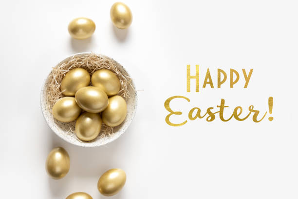 istock Easter greeting card with golden chicken eggs on white background. Text - Happy Easter. Top view. 1217213509