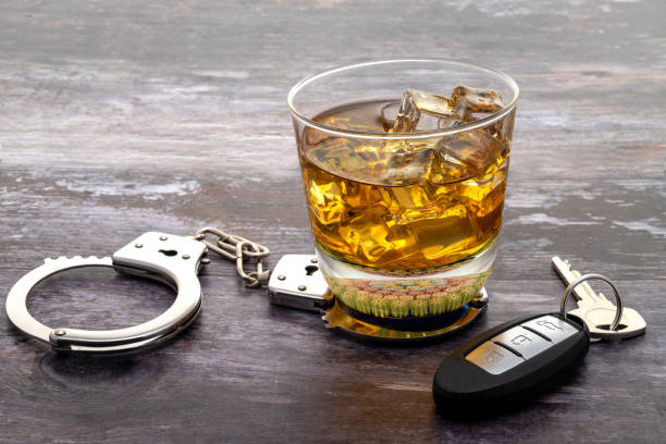 Glass of whiskey with a set of car keys A glass of whiskey with a set of car keys and handcuffs highlighting the dangers of drinking and driving driving under the influence stock pictures, royalty-free photos & images