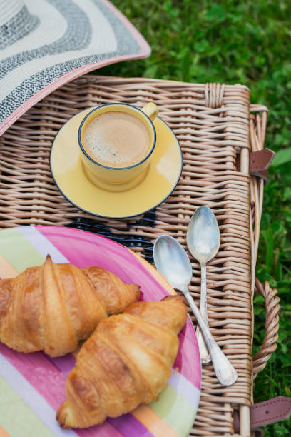 Breakfast on the grass. Cup of coffee and French croissants