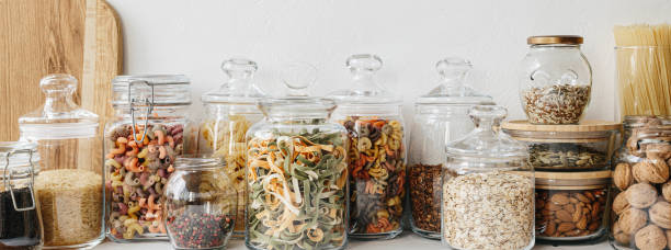 istock Various cereals and seeds in glass jars on the white textured background. Kitchen interior ideas. Eco friendly kitchen, zero waste home concept 1217217143