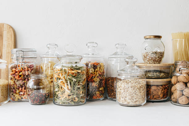 istock Various cereals and seeds in glass jars on the white textured background. Kitchen interior ideas. Eco friendly kitchen, zero waste home concept 1217217196