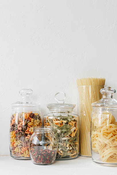 istock Various cereals and seeds in glass jars on the white textured background. Kitchen interior ideas. Eco friendly kitchen, zero waste home concept 1217217238