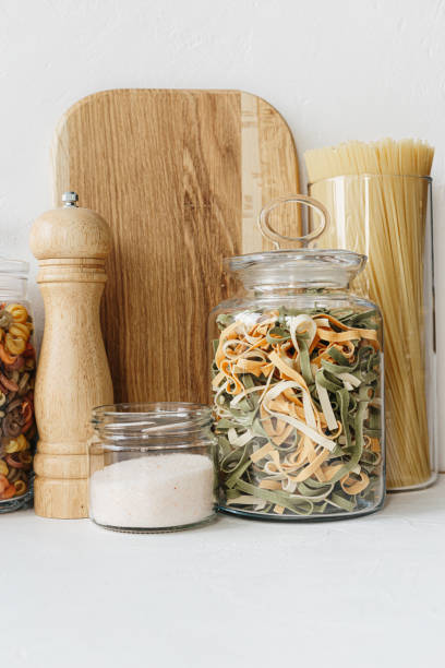 istock Various cereals and seeds in glass jars on the white textured background. Kitchen interior ideas. Eco friendly kitchen, zero waste home concept 1217217354
