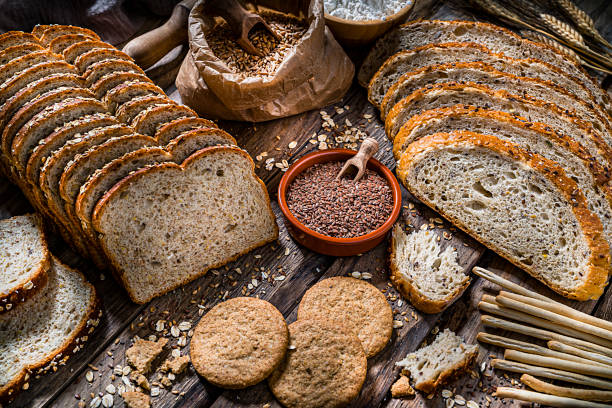 comida saludable: pan integral con semillas y cereales en la mesa de cocina rústica - pan de centeno fotografías e imágenes de stock