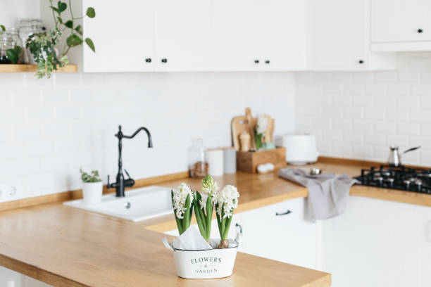 istock Modern white u-shaped kitchen in scandinavian style. Spring decoration spring flowers 1217218097