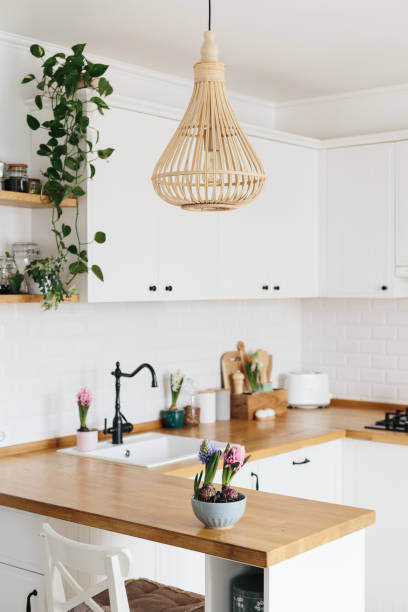 istock Modern white u-shaped kitchen in scandinavian style. Spring decoration spring flowers 1217218169