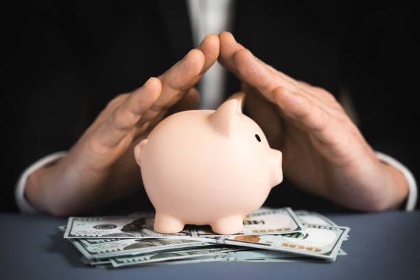 Money Protecting concept. Saving symbol - Close-up Of A Human Hand Protecting Pink Piggy Bank Money Protecting concept. Saving symbol - Close-up Of A Human Hand Protecting Pink Piggy Bank wealthy stock pictures, royalty-free photos & images
