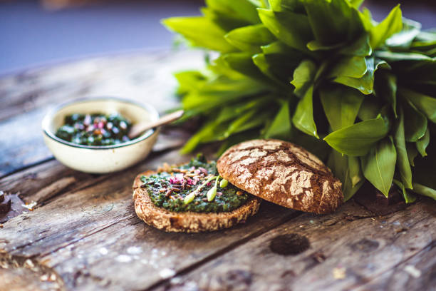 Fresh Wild Garlic Pesto or ramson with Sourdough Bread on a rustic wooden table