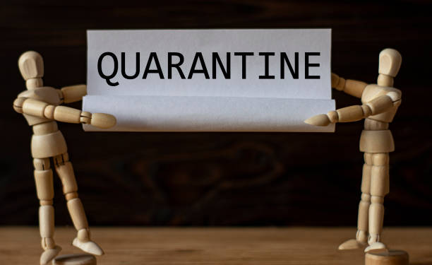 istock Two wooden men hold paper with the word QUARANTINE 1217220089