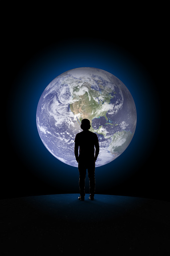 Teen from behind watching the planet Earth from outer space