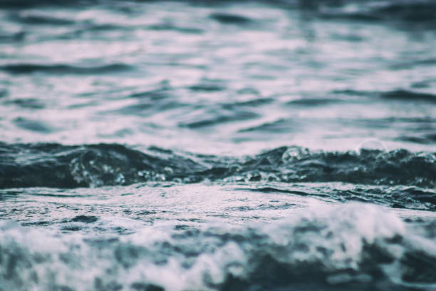 Waves close-up with spray and foam on the seashore is an abstract background. Close-up, shallow focus.