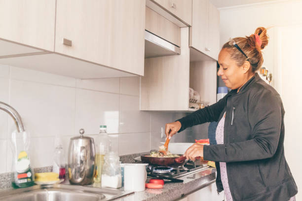 istock A self isolate woman following online instructions on her mobile phone and cooking dinner in Covid-19 Corona Virus time. 1217227848