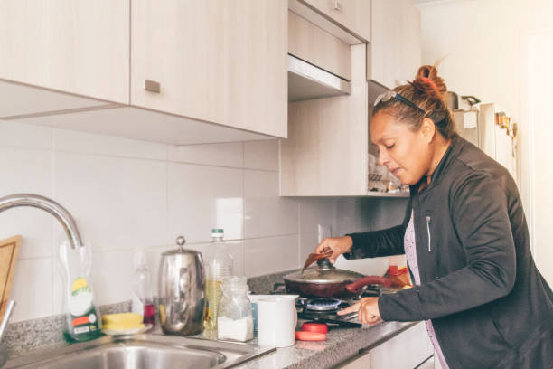istock A self isolate woman following online instructions on her mobile phone and cooking dinner in Covid-19 Corona Virus time. 1217227913