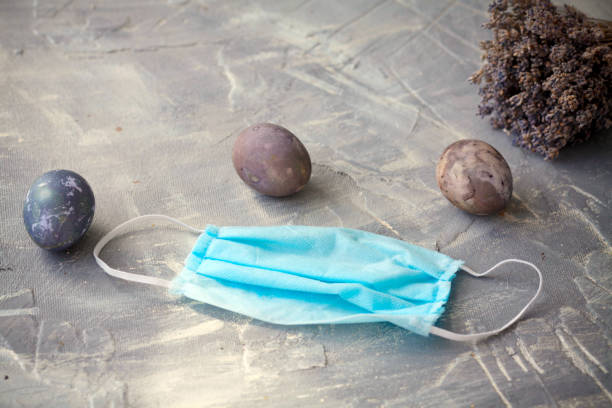 istock Easter eggs and medina mask on a gray background. Quarantine, stay home concept. 1217227980
