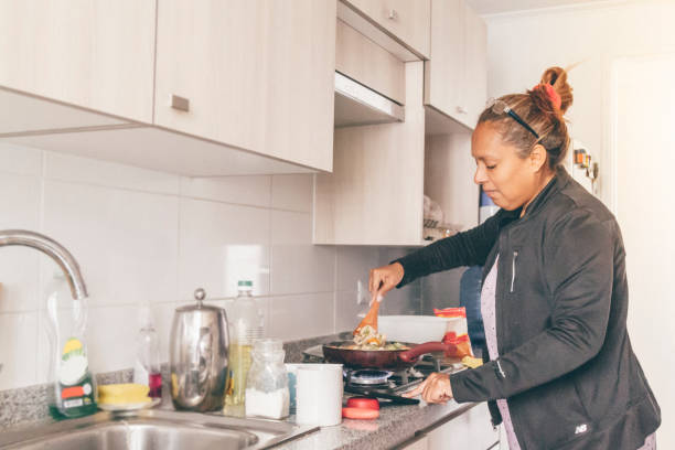 istock A self isolate woman following online instructions on her mobile phone and cooking dinner in Covid-19 Corona Virus time. 1217228054