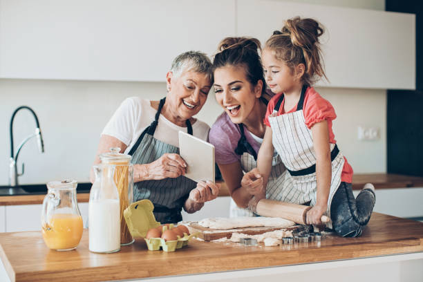 stiamo provando una nuova ricetta - grandmother senior adult family domestic kitchen foto e immagini stock