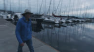 istock A Man in His Sixties Walks by Sailboats Parked at a Dock in Puget Sound near Seattle, Washington on an Overcast Day 1217231367