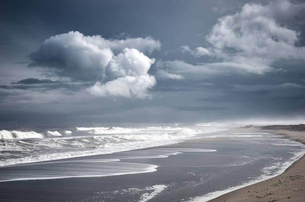istock Stormy sea, beach and white clouds at dark sky 1217231385