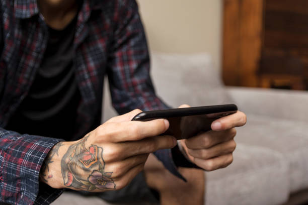 istock Young man paying a mobile game at home. Smart phone gaming 1217234621