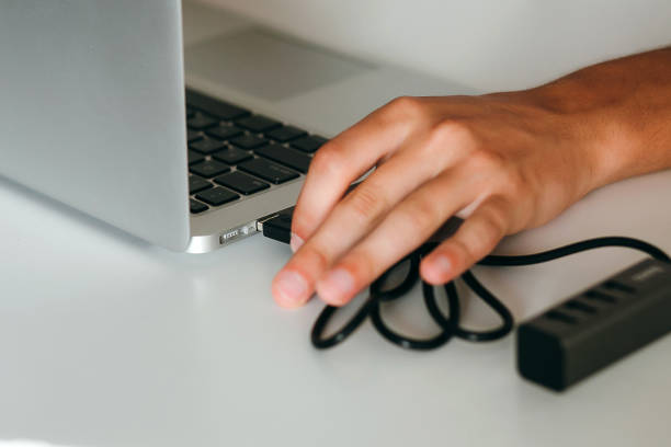 istock Closeup hand connecting usb-hub to laptop 1217234845
