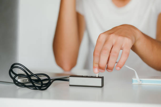 istock Man's hands connecting powerbank to a laptop through usb-hub 1217235001
