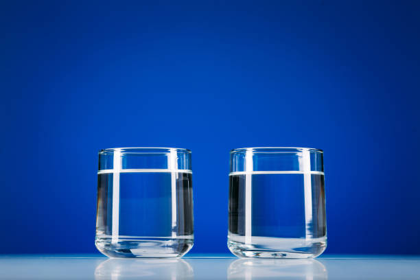 istock Two Glasses of water isolated on blue background 1217235028