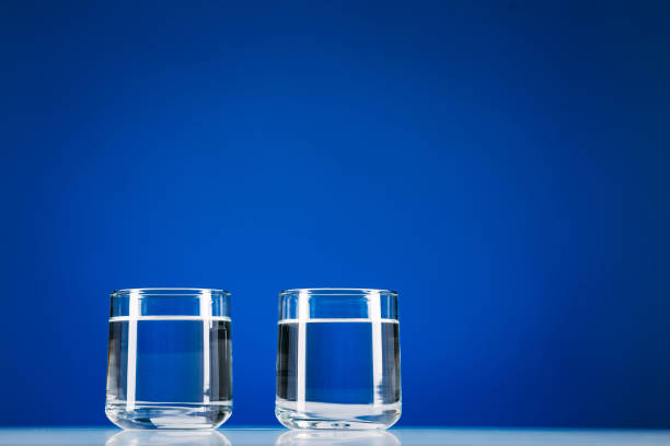 istock Two Glasses of water isolated on blue background 1217235180