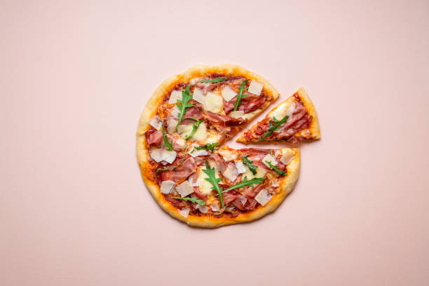 нарезанная пицца ветчина и сыр на розовом фоне - parmesan cheese cheese portion italian culture стоковые фото и изображения