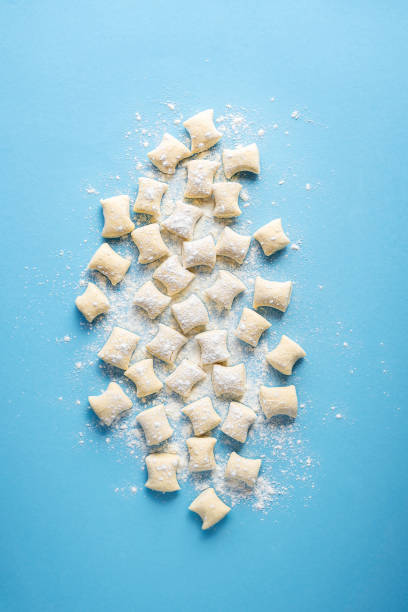 Uncooked gnocchi pile. Cheese gnocchi dumplings on flour