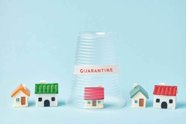 istock Coronavirus quarantine concept. Small houses covered with transparent plastic cup and inscription Quarantine 1217238716