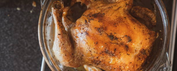istock Whole free range chicken roasted in the oven. Winner Winner Chicken Dinner. roasted free range chicken on slate stone background. Modern chicken dinner meal. Roasted healthy meat meal. Top view vivid filter. Baked whole chicken with mushrooms and potatoes 1217238754