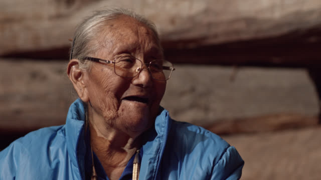 A Native American (Navajo) Woman in Her Eighties Talks to and Laughs with a Man in His Forties while They Eat