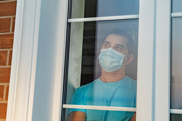 istock Infected man in medical mask on self-isolation 1217242065