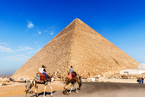Cairo, Egypt - December 31, 2014: View at the Pyramid in Giza and tourists riding on the camels