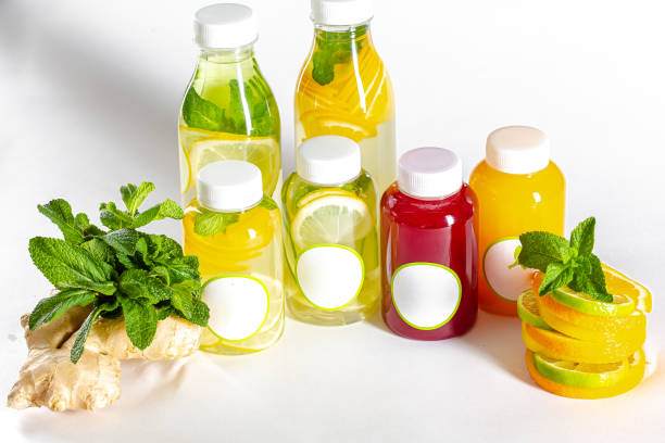 istock White isolated background, plastic bottles with fruit and berry mixes, with slices inside the bottles, next to slices of lemon, lime and mint, ginger 1217243538