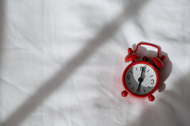 istock Red analog clock on white rumpled sheets. Top view, flat lay, copy spase. Horizontal. Concept of awakening, sleep, early rise, productivity, productive day. For social media, blog. Minimal style 1217243939