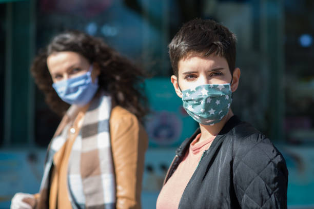 mulheres na cidade usando máscaras faciais protetoras e luvas de proteção - smog city pollution town - fotografias e filmes do acervo