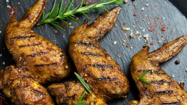 istock grilled chicken wings with red sauce on a black stone surface 1217246701