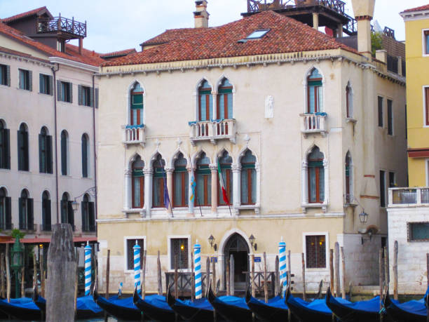 istock Venice's traditional building with gondolas moored on traditional venetian's mooring post 1217247109