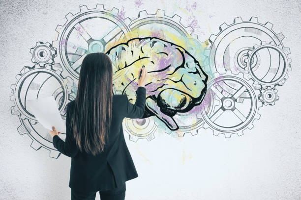istock Businesswoman drawing cogs and brain sketch 1217249854