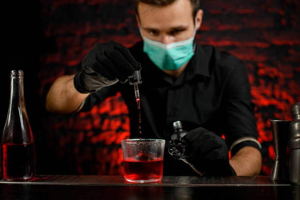 istock Professional barman pour ingredient to cocktail using pipette. 1217250785
