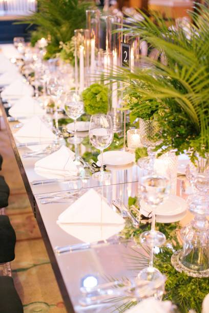 istock Palm tree leaf wedding table. Candles, napkins and mirrored tables. 1217261164