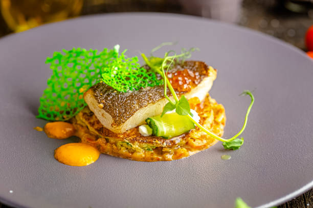 wooden rustic background, top and side, on a round plate, fried fish meat fillet, with greens and vegetables, with a green twig