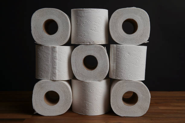 многие рулоны туалетной бумаги сложены в tic-tac-toe игрушка форме. мягкая гигиеническая бумага. таблица из черного фона. - paper towel hygiene public restroom cleaning стоковые фото и изображения