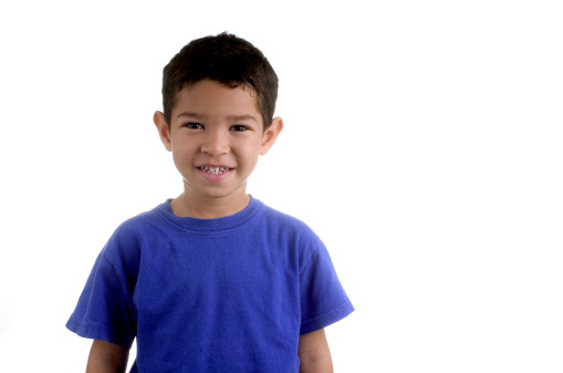 Portrait of a smiling little brown haired boy looking at the camera. Happy kid with good healthy teeth for dental on blue background