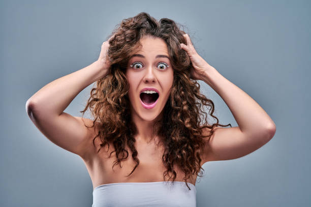 istock Hysterical woman expression with her hands on the head on a grey isolated background 1217268533